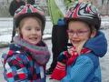 Twee kinderen met een schaatshelm op de ijsbaan